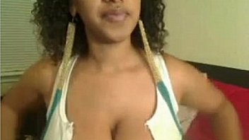 Curly hair Latino exposes her breasts and plays with dildo
